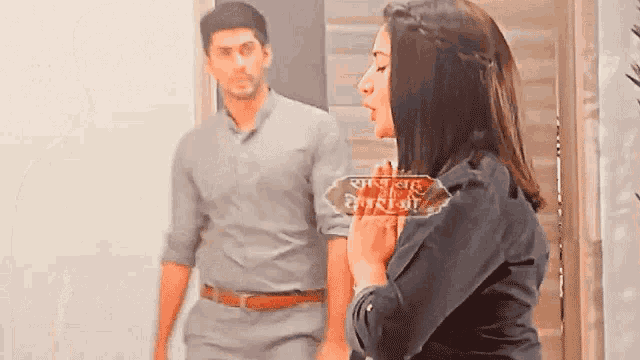a man and a woman are standing next to each other in a room