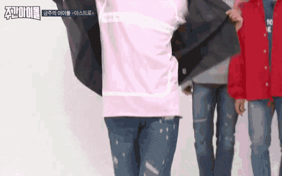a group of people standing next to each other with one wearing a pink shirt and a red jacket .
