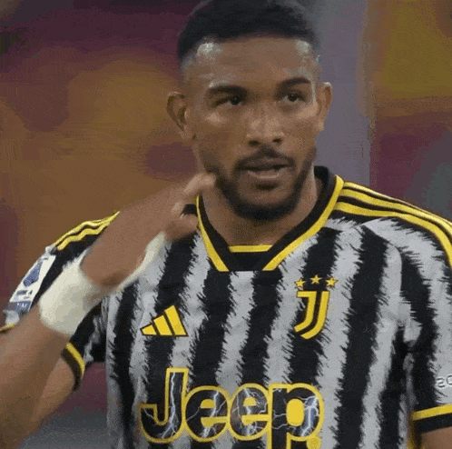 a soccer player wearing a jeep jersey looks at the camera
