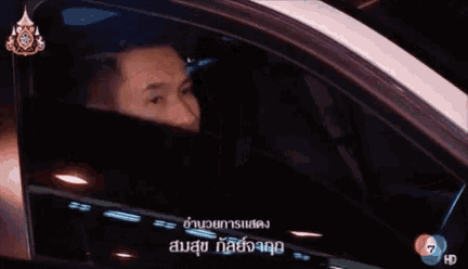 a man is driving a car with the number 7 on the side