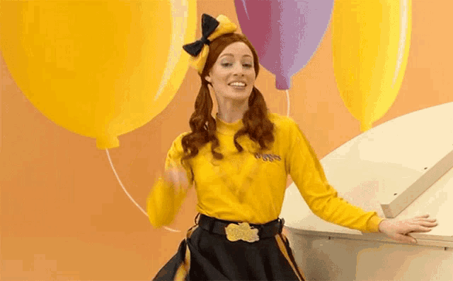 a woman in a yellow shirt with the word wiggles on it