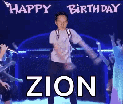 a man with a backpack is dancing on a stage with the words happy zion written above him .