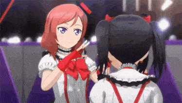 a couple of anime girls are standing next to each other on a stage and making a peace sign .