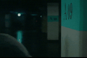 a man is talking on a cell phone in front of a sign that has the letter a on it