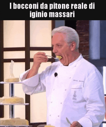 a man in a white chef 's coat is eating something with a spoon
