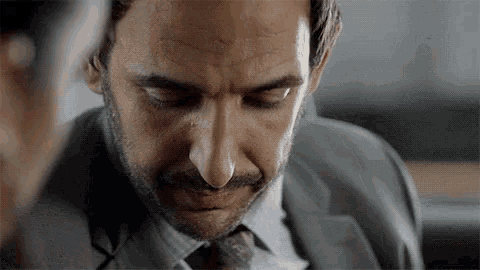 a man in a suit and tie is looking down
