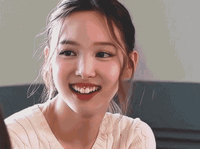 a close up of a woman 's face with a smile on her face .