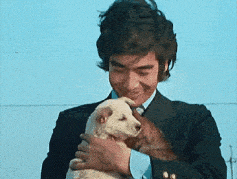 a man in a suit is holding a puppy in his hands