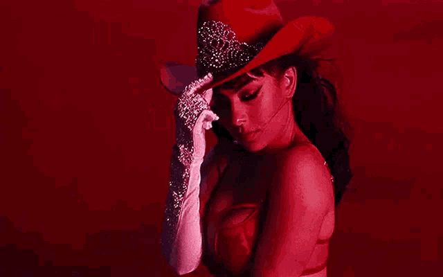 a woman wearing a red cowboy hat and white gloves