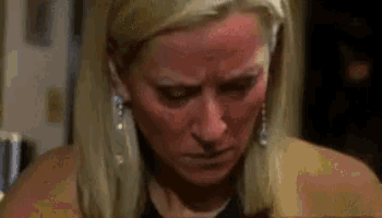 a close up of a woman 's face with a red spot on it .