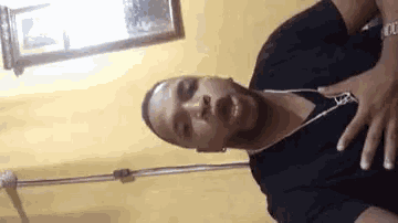 a man wearing headphones and a black shirt is standing in a room .