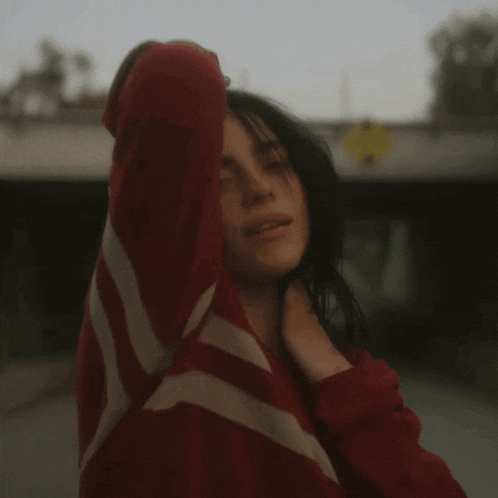 a woman in a red and white striped shirt is covering her face