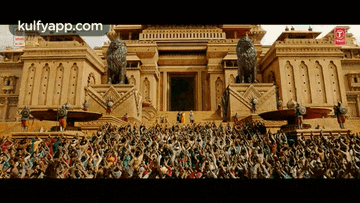 a large crowd of people are gathered in front of a large building with the words kulfyapp.com on the bottom right
