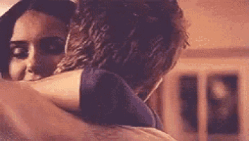 a man and a woman are hugging and kissing in a room .