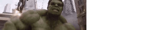 a close up of the hulk 's face in a city with buildings in the background .