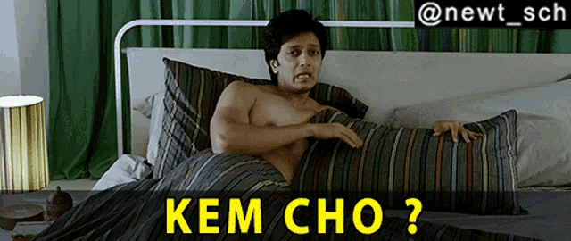 a shirtless man is laying on a bed with a striped comforter and the caption kem cho