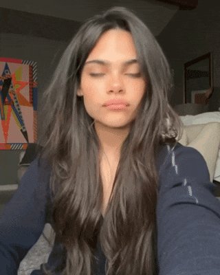 a woman with long dark hair is taking a selfie