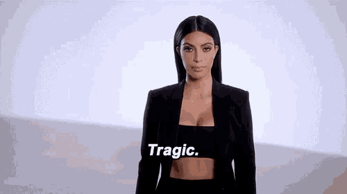 a woman is wearing a black jacket and a black crop top and says tragic