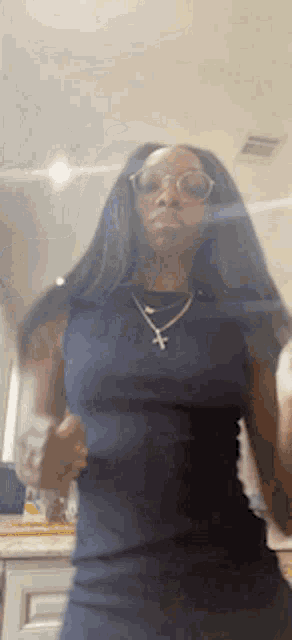 a woman wearing glasses and a necklace with a cross on it