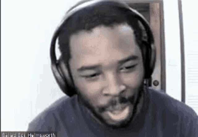 a man with a beard wearing headphones is making a funny face