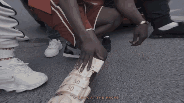 a man is holding a stack of 50 euro bills