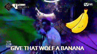a man is standing next to a banana and says give that wolf a banana .