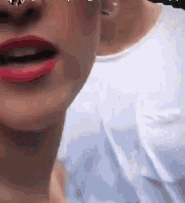 a close up of a woman 's face with red lips and a nose ring