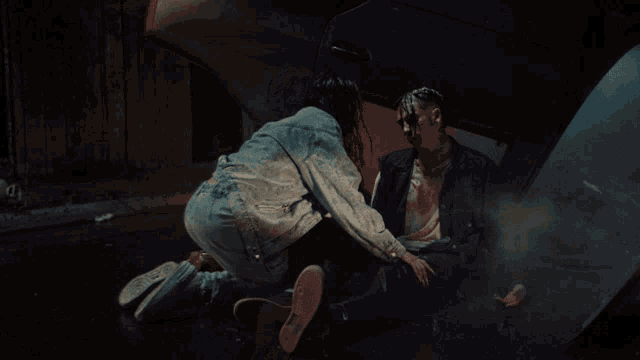 a man with blood on his face is being helped by a woman in a denim jacket