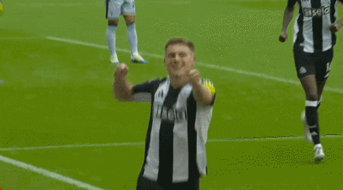 a soccer player is celebrating a goal with his teammates on the field .