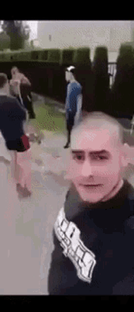 a man taking a selfie with a group of people behind him .