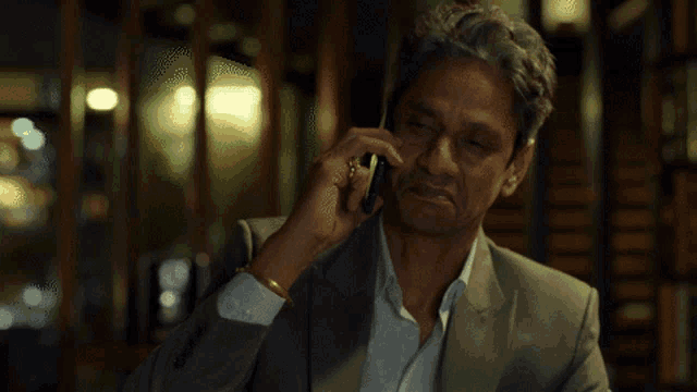 a man in a suit is talking on his cell phone