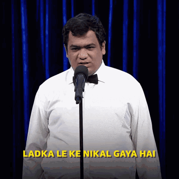 a man stands in front of a microphone with the words ' ladki le ke nikal gaya hai ' on the bottom