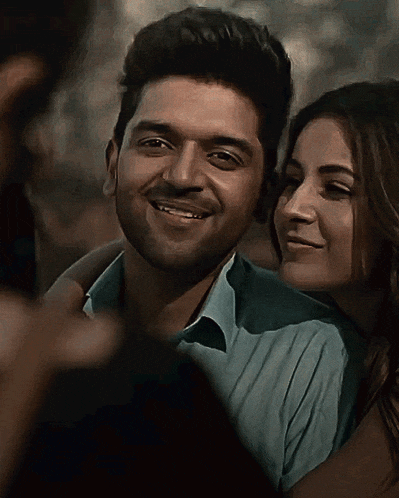 a man and woman are posing for a picture and the woman is smiling