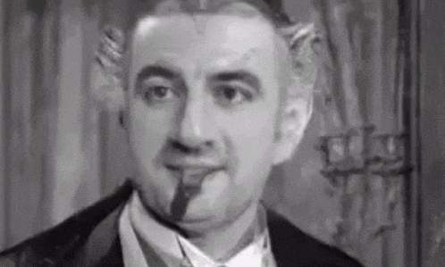 a black and white photo of a man in a tuxedo with horns .