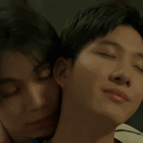 a close up of two men 's faces with one 's eyes closed