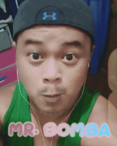 a man wearing an under armour hat and a green tank top with the name mr. bomba on it