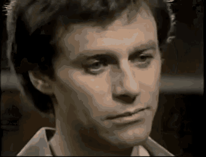 a close up of a man 's face with a serious look on his face in a black and white photo .