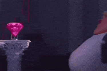 a man in a suit and tie is standing next to a large pink diamond