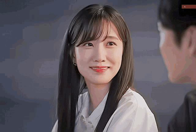 a woman with long hair is smiling at a man
