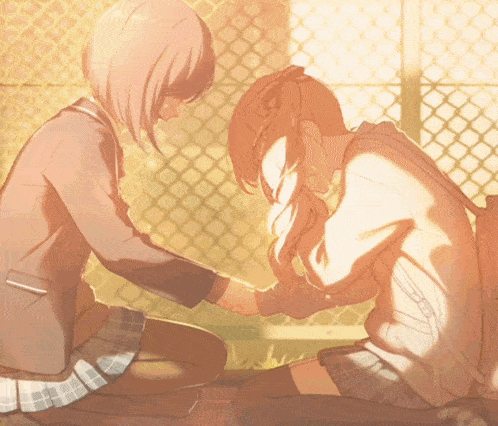 a girl is kneeling down next to another girl and touching her hair