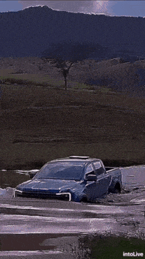 a blue car is driving down a street at night with the words intolive at the bottom