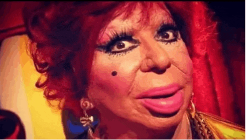 a close up of a woman 's face with a lot of makeup on .