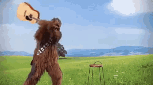 a chewbacca holding a guitar in a field