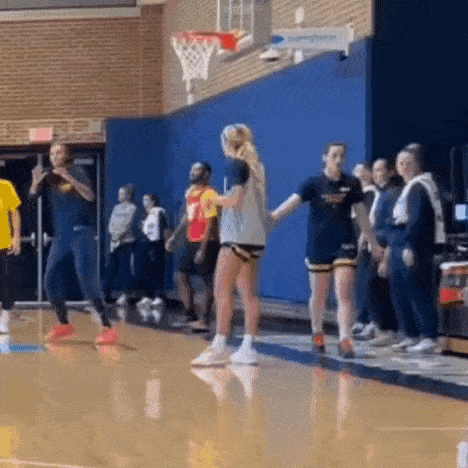 a group of people are playing basketball on a court .