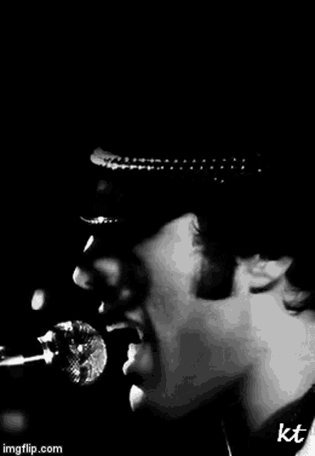 a close up of a man singing into a microphone
