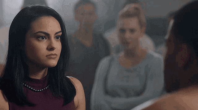 a woman in a purple top is looking at a man