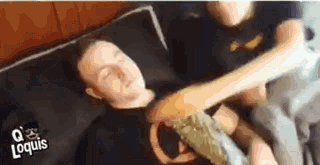 a man is laying on a bed with his arm around another man .