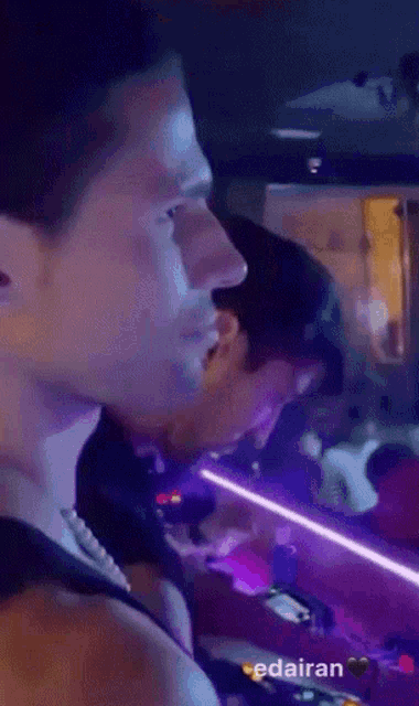 a purple light is shining on a man 's face and the word edairan is on the bottom