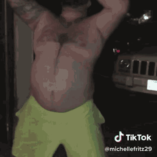 a man without a shirt is dancing in front of a jeep and a tiktok logo