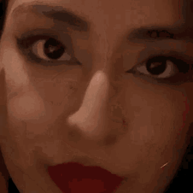 a close up of a woman 's face with red lipstick on it